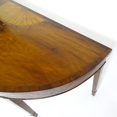 1573 - A large late 18thC mahogany serving table of demi lune form, having a marquetry inlaid top with sunb... 