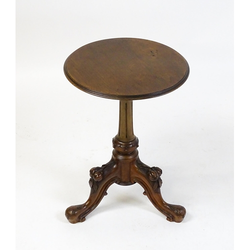 1589 - A Victorian mahogany wine table with a circular top above a turned, fluted pedestal and raised on th... 