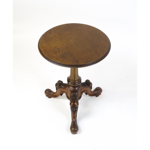 1589 - A Victorian mahogany wine table with a circular top above a turned, fluted pedestal and raised on th... 