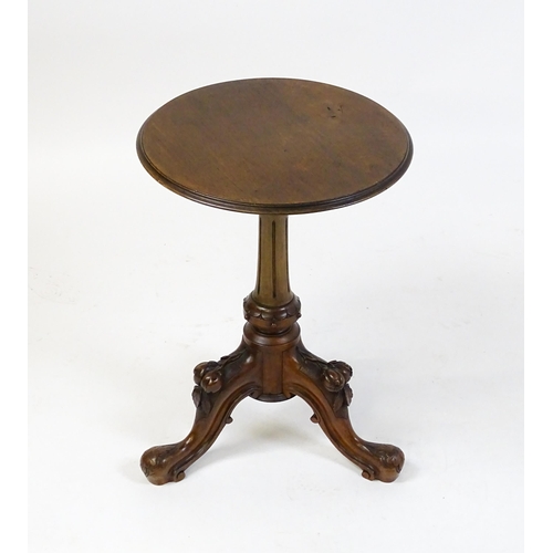 1589 - A Victorian mahogany wine table with a circular top above a turned, fluted pedestal and raised on th... 