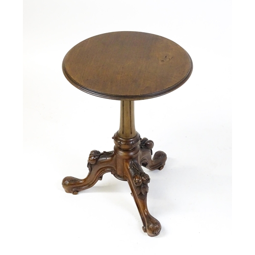 1589 - A Victorian mahogany wine table with a circular top above a turned, fluted pedestal and raised on th... 