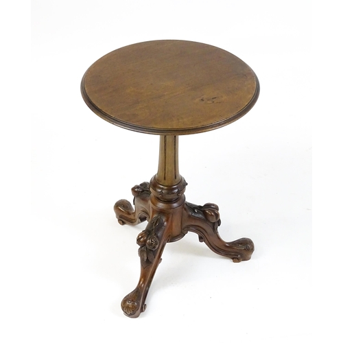 1589 - A Victorian mahogany wine table with a circular top above a turned, fluted pedestal and raised on th... 