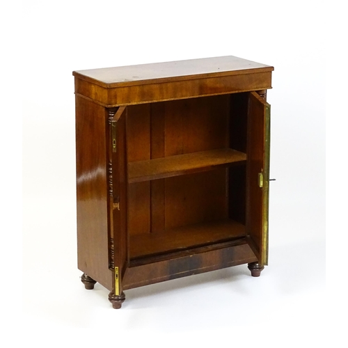 1599 - A 19thC mahogany cupboard with a rectangular top above two panelled doors flanked by turned tapering... 