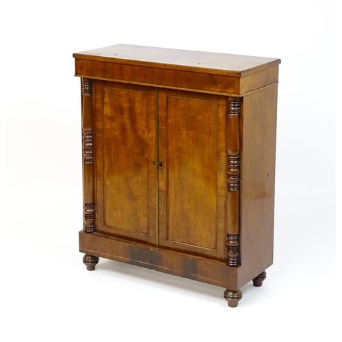 1599 - A 19thC mahogany cupboard with a rectangular top above two panelled doors flanked by turned tapering... 