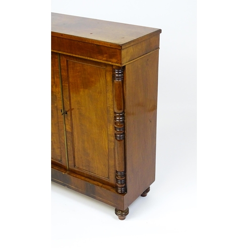 1599 - A 19thC mahogany cupboard with a rectangular top above two panelled doors flanked by turned tapering... 