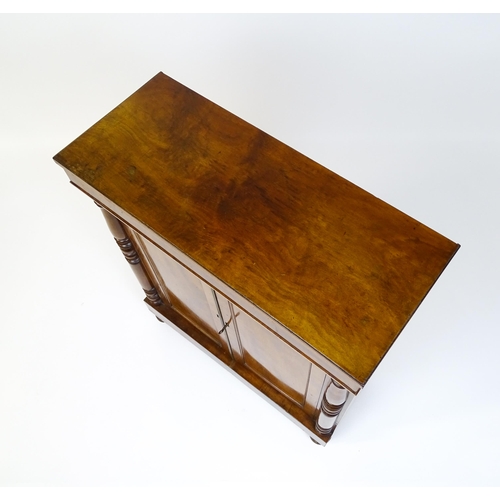 1599 - A 19thC mahogany cupboard with a rectangular top above two panelled doors flanked by turned tapering... 