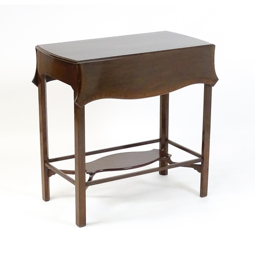 1614 - An Edwardian mahogany tea table with a crossbanded top and two shaped leaves raised on four legs uni... 