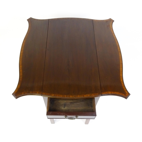 1614 - An Edwardian mahogany tea table with a crossbanded top and two shaped leaves raised on four legs uni... 