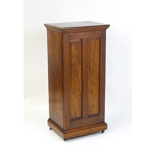 1618 - An early 20thC pine cabinet with a moulded top and panelled door concealing four shelves, the cabine... 