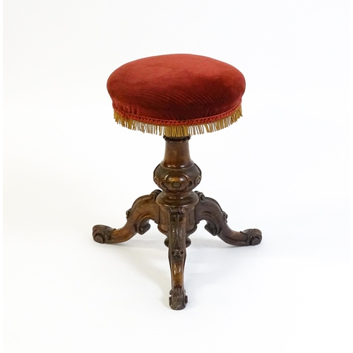 1619 - A mid / late 19thC walnut piano stool with a circular adjustable seat raised on three carved cabriol... 