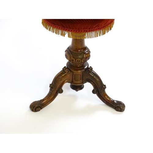 1619 - A mid / late 19thC walnut piano stool with a circular adjustable seat raised on three carved cabriol... 