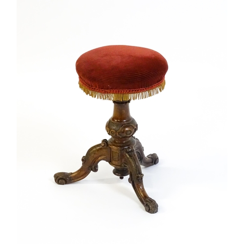 1619 - A mid / late 19thC walnut piano stool with a circular adjustable seat raised on three carved cabriol... 