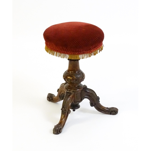 1619 - A mid / late 19thC walnut piano stool with a circular adjustable seat raised on three carved cabriol... 