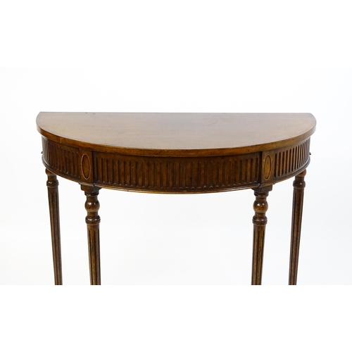 1630 - A 20thC mahogany demi-lune side table with a cross banded top, fluted frieze, and raised on four tur... 