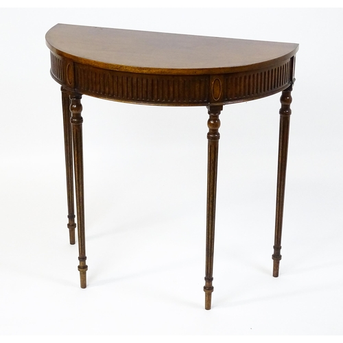 1630 - A 20thC mahogany demi-lune side table with a cross banded top, fluted frieze, and raised on four tur... 