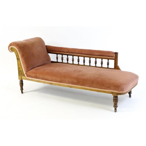 1695 - An early 20thC chaise longue with a scrolled end decorated with carved floral decoration and raised ... 