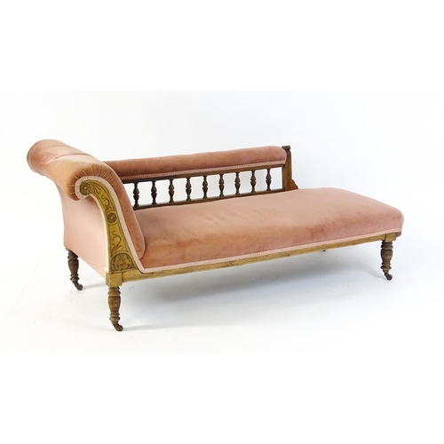 1695 - An early 20thC chaise longue with a scrolled end decorated with carved floral decoration and raised ... 