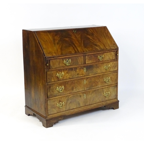 1707 - A late 18thC mahogany bureau with a fall front above two short over three long graduated drawers wit... 