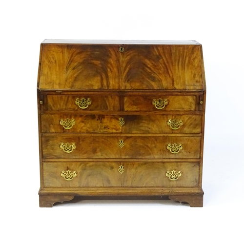 1707 - A late 18thC mahogany bureau with a fall front above two short over three long graduated drawers wit... 