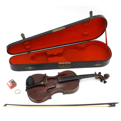 1373 - Musical Instrument: a cased early 20thC continental violin and bow, the interior bearing label 'Carl... 