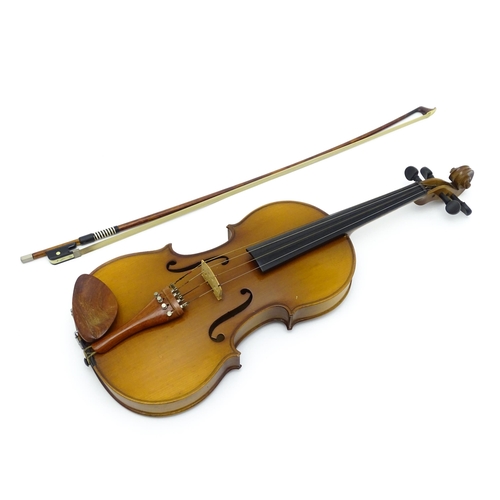 1374 - Musical Instrument: a cased late 20thC violin and bow, the interior bearing label 'Imported by Lesli... 