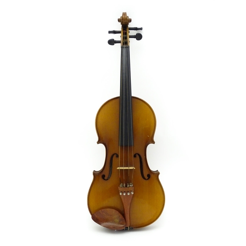 1374 - Musical Instrument: a cased late 20thC violin and bow, the interior bearing label 'Imported by Lesli... 