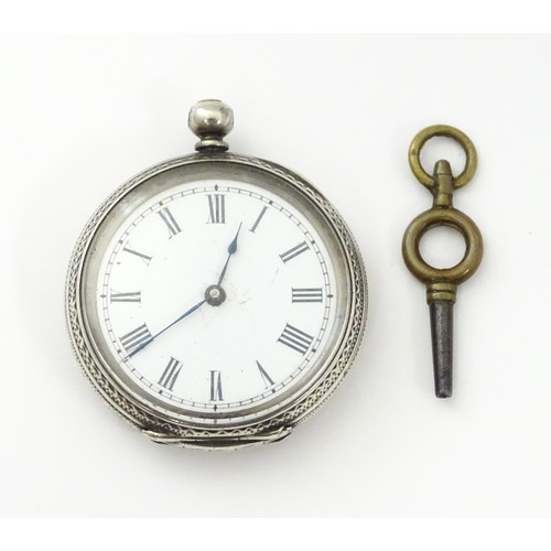 760 - A white metal cased fob watch, the white enamel dial having Roman numerals. Together with a watch ke... 