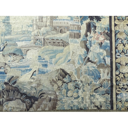 1383 - A late 17th / early 18thC Brussels tapestry depicting a pastoral tree lined landscape with castle by... 