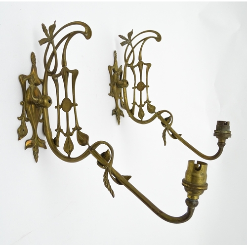 1533 - A pair of Art Nouveau brass wall lights with scrolling floral and foliate detail. Approx. 14