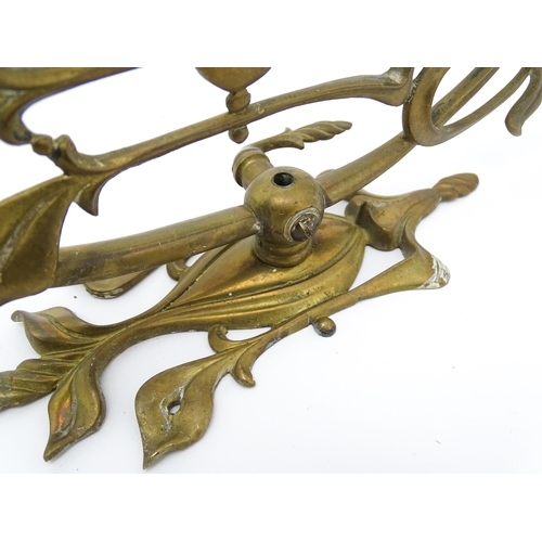 1533 - A pair of Art Nouveau brass wall lights with scrolling floral and foliate detail. Approx. 14