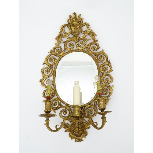 1548 - A 20thC girandole / electrolier with an oval bevelled mirror, three branches, with pierced and scrol... 