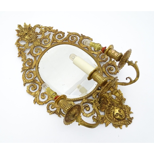 1548 - A 20thC girandole / electrolier with an oval bevelled mirror, three branches, with pierced and scrol... 