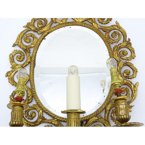 1548 - A 20thC girandole / electrolier with an oval bevelled mirror, three branches, with pierced and scrol... 