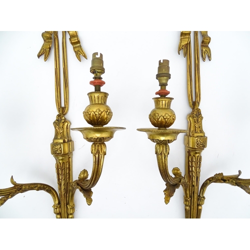 1550 - A pair of brass 20thC twin branch wall sconces with bow cresting and acanthus scroll detail. Approx.... 