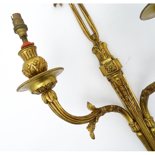 1550 - A pair of brass 20thC twin branch wall sconces with bow cresting and acanthus scroll detail. Approx.... 