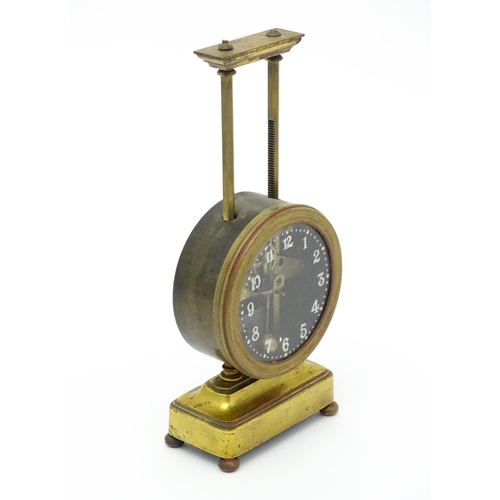 1515 - A gilt brass cased gravity clock, the dial with Arabic numerals. Approx. 9 1/2