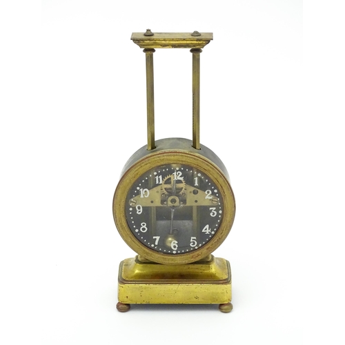 1515 - A gilt brass cased gravity clock, the dial with Arabic numerals. Approx. 9 1/2