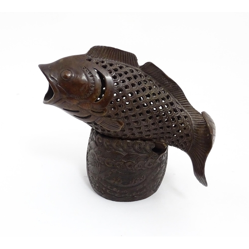 1020 - A Chinese bronze incense burner modelled as a fish on a stand decorated with crashing waves. Charact... 