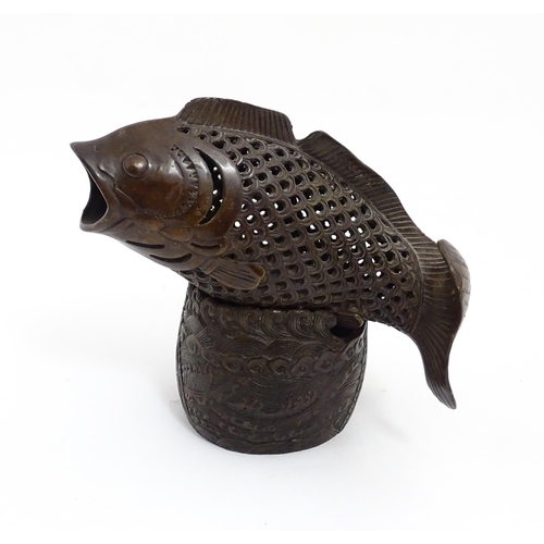 1020 - A Chinese bronze incense burner modelled as a fish on a stand decorated with crashing waves. Charact... 