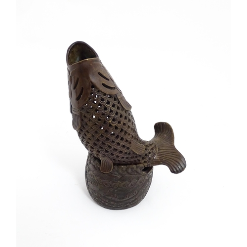 1020 - A Chinese bronze incense burner modelled as a fish on a stand decorated with crashing waves. Charact... 