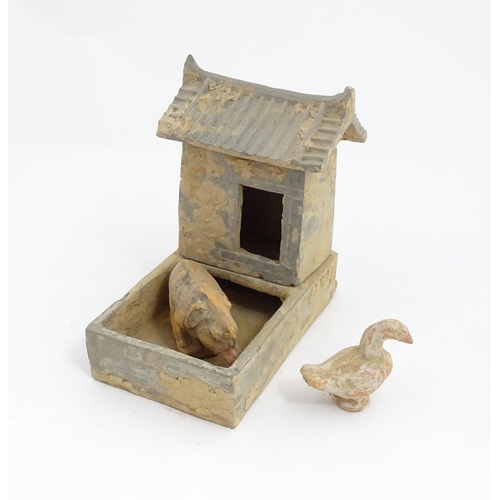 1033 - A Chinese Han dynasty pottery model of a pig sty with hut, a model of a boar and a model of a duck. ... 