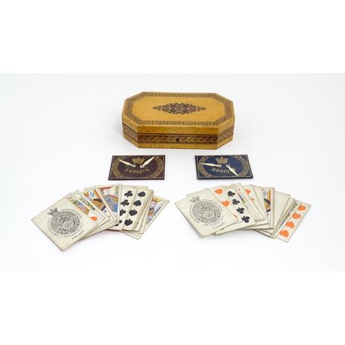 1062 - A 19thC Tunbridge ware games box of octagonal form with banded decoration, opening to reveal four se... 