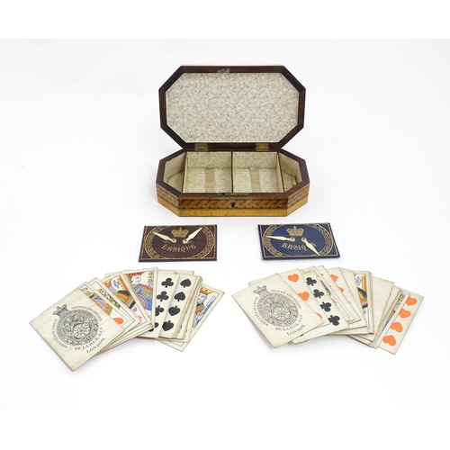 1062 - A 19thC Tunbridge ware games box of octagonal form with banded decoration, opening to reveal four se... 