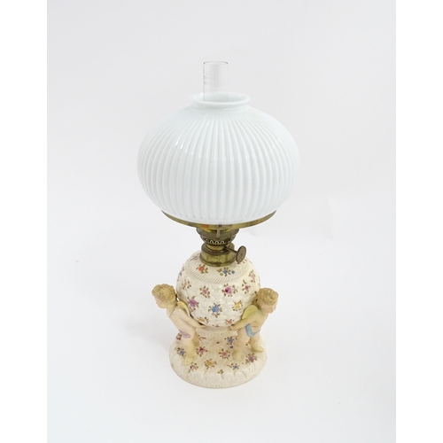 1540 - A Continental oil lamp, the German Sitzendorf style base with cherubs detail and floral decoration. ... 