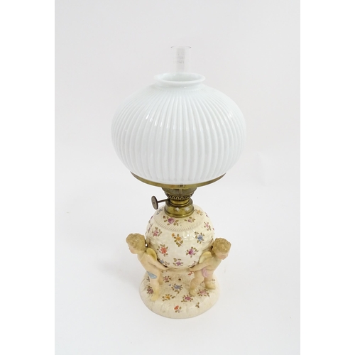 1540 - A Continental oil lamp, the German Sitzendorf style base with cherubs detail and floral decoration. ... 