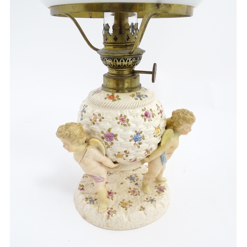 1540 - A Continental oil lamp, the German Sitzendorf style base with cherubs detail and floral decoration. ... 