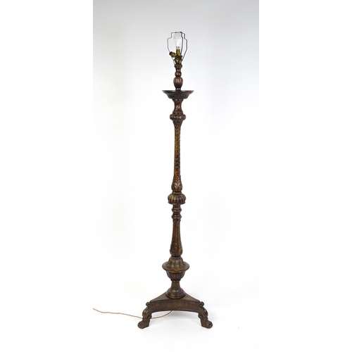 1555 - A mahogany carved and turned column standard lamp with triform base having scroll and paw feet. Appr... 