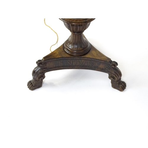 1555 - A mahogany carved and turned column standard lamp with triform base having scroll and paw feet. Appr... 