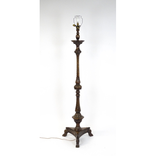 1555 - A mahogany carved and turned column standard lamp with triform base having scroll and paw feet. Appr... 