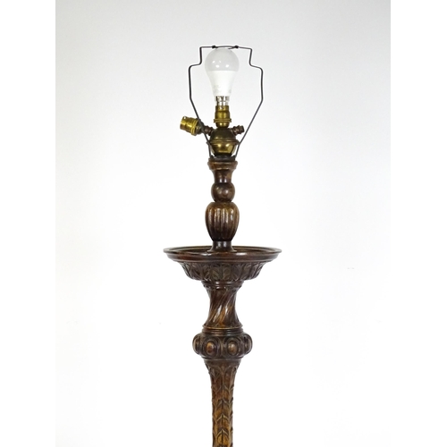 1555 - A mahogany carved and turned column standard lamp with triform base having scroll and paw feet. Appr... 